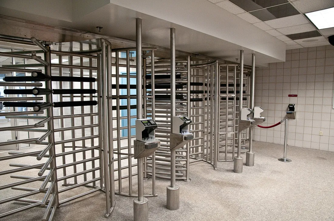 Full-height turnstile access gates controlling a secure entrance
